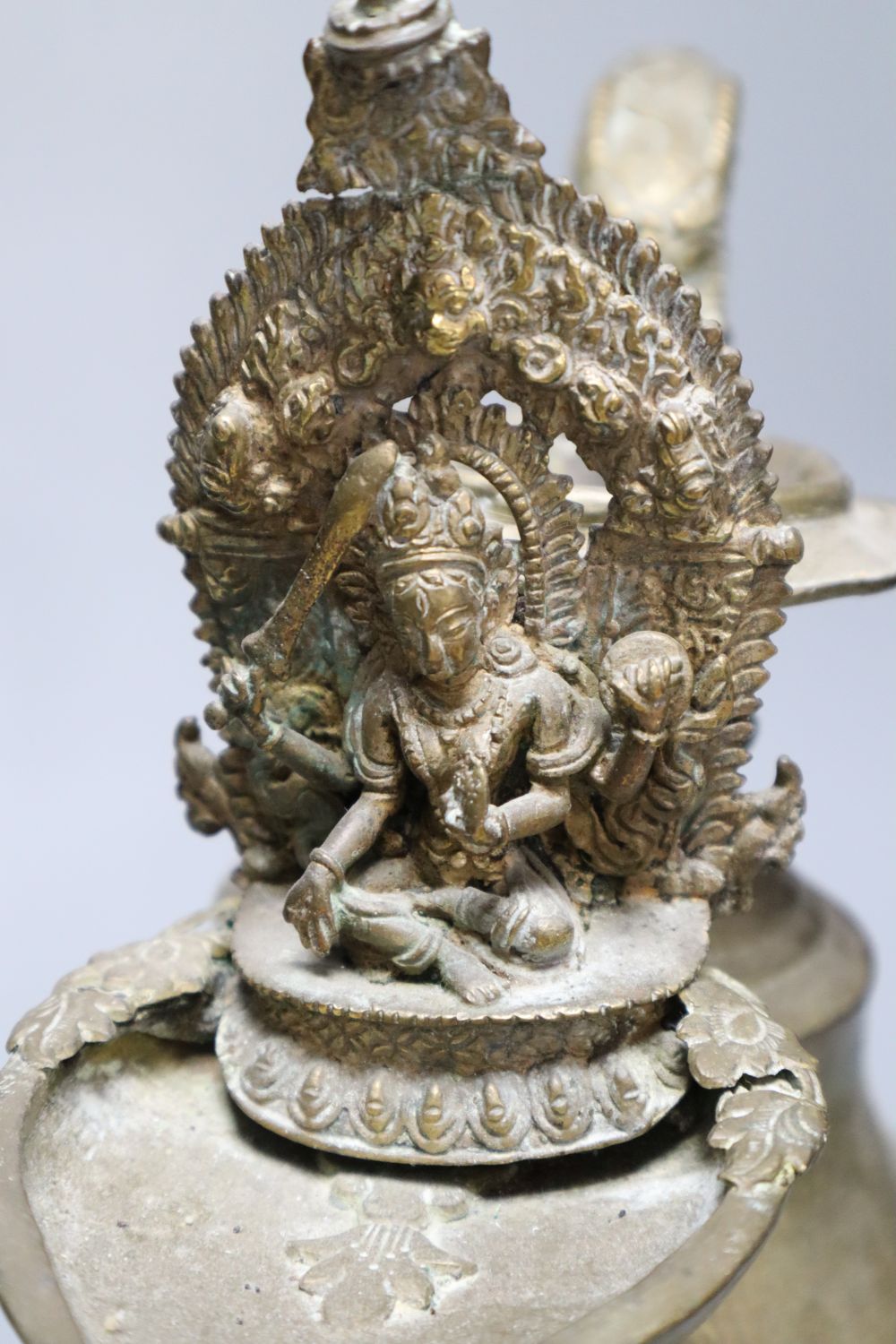 A Himalayan Buddhist brass lamp/ewer with related ladle, 26cm, 19th/20th century and a carved black mineral Chinese stone figure
